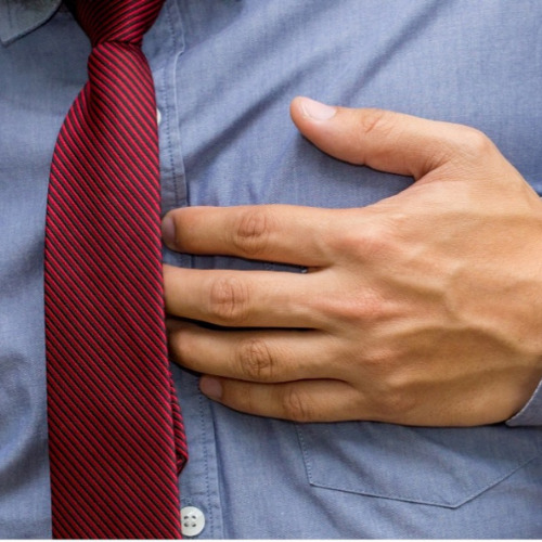 man holding chest with heartburn